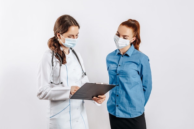 Woman patient at doctor in masks at reception to check health on white isolated background