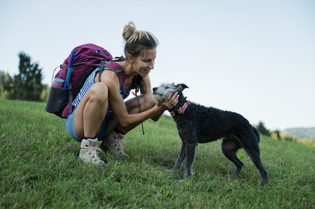 Woman patting her dog on a hike