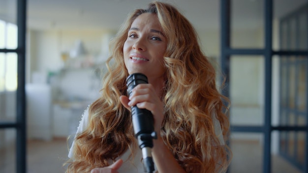 Woman performing musical song in microphone Cheerful singer practicing vocal