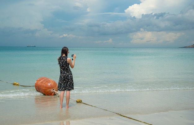 Woman photographed with a smartphone at Nam Sai Beach, Chonburi, Thailand