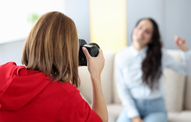 Photo woman photographer photographs model on couch closeup