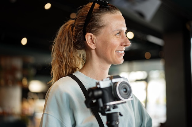 Woman photographer with professional camera indoors closeup