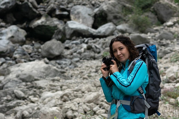 A woman photographs the landscape in the mountains.