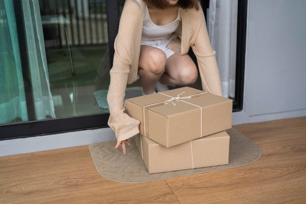 Woman pick up the parcel box to door contactless delivery during a pandemic covid Online shopping