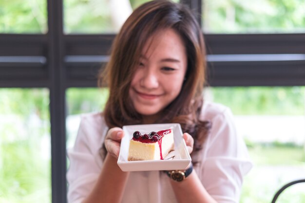 woman and a piece of blueberries cheese cake