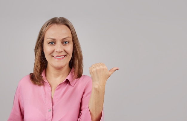 woman in a pink blouse smiling looks at the camera