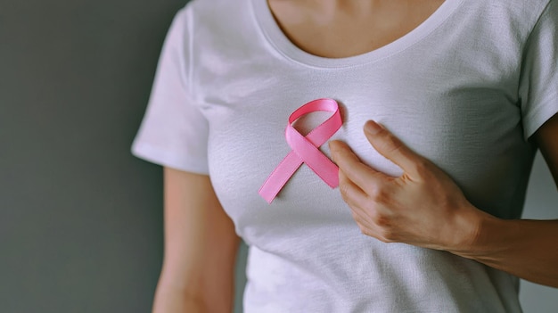 Woman Pinning Pink Ribbon on White Shirt for Awareness