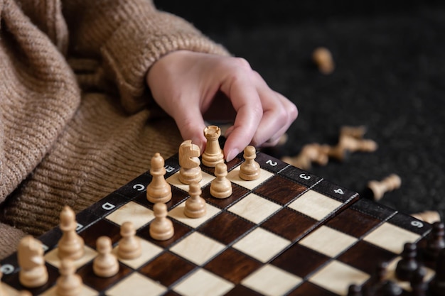 Woman placing chess pieces on a chessboard