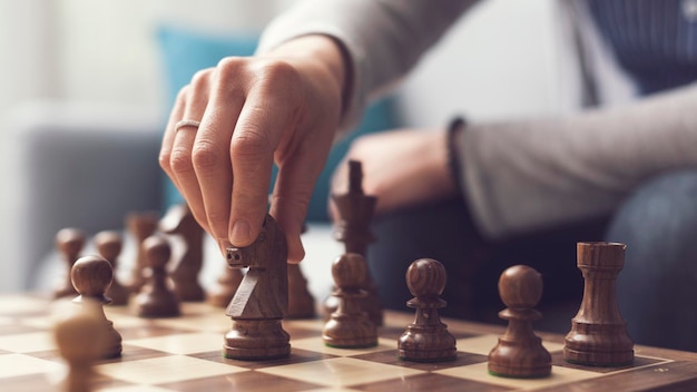 Woman playing chess hand close up