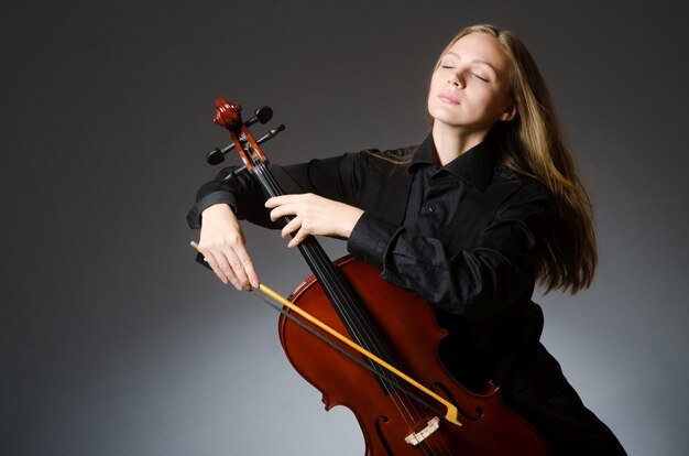 Woman playing classical cello in music concept