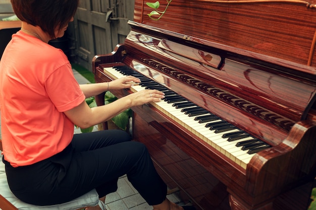 woman playing piano back view