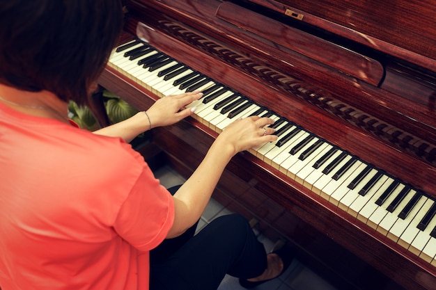 woman playing piano back view