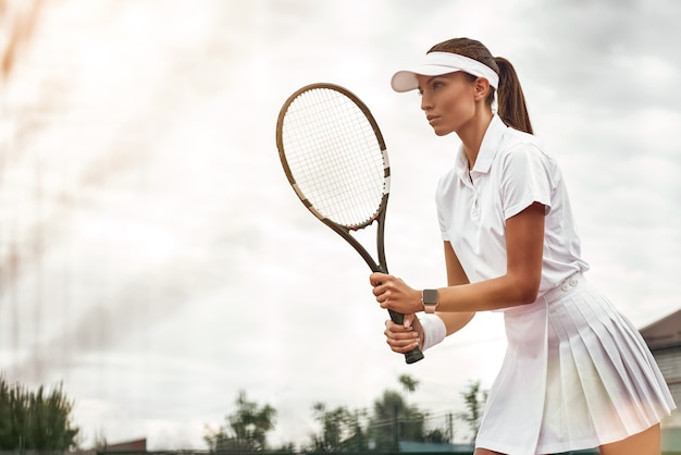 Woman playing tennis and waiting for the service