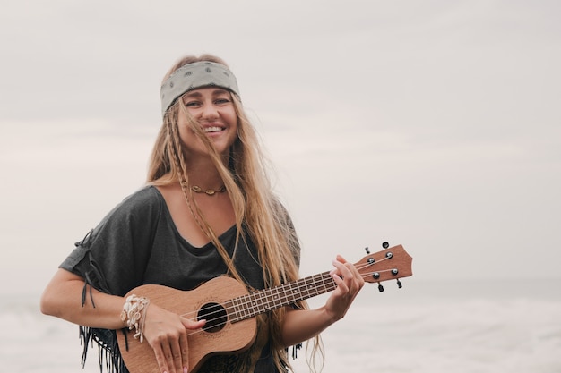 woman playing ukulele on sea background