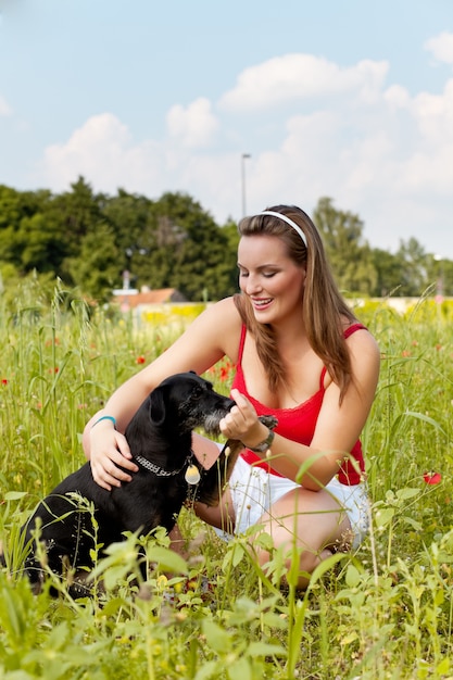 Woman playing with her dog in a meadow