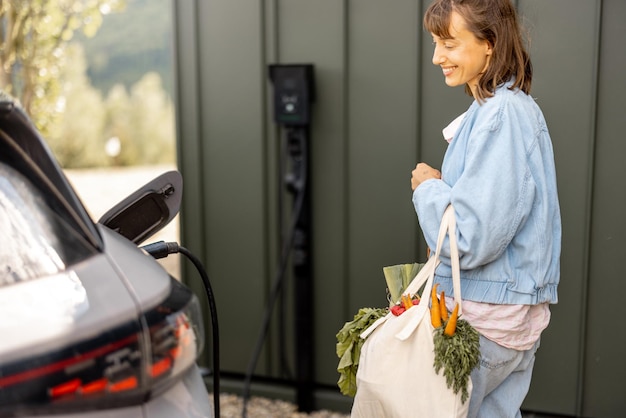 Woman plugging a charger into electric vehicle