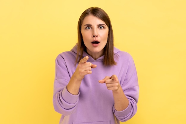 Woman pointing to camera with surprised shocked expression and open mouth