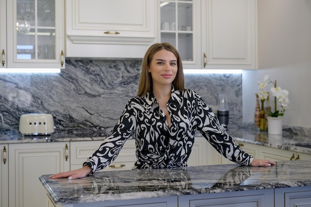 A woman poses in a kitchen with a traditional and sleek design