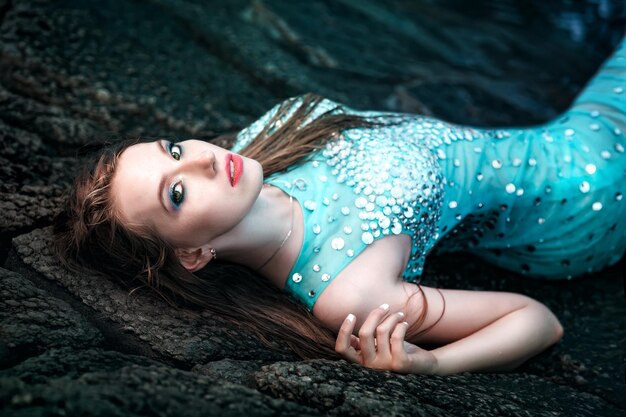 Woman posing on a beach with rocks