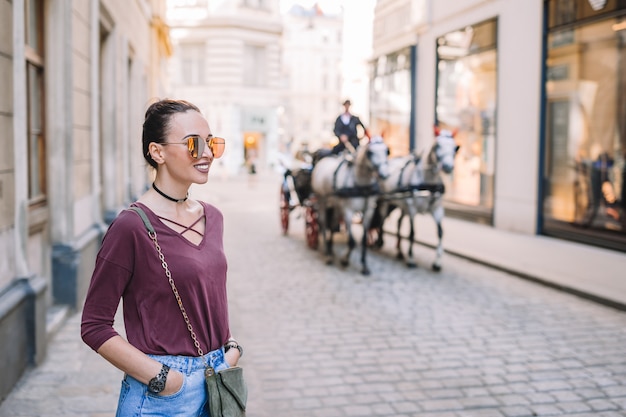 Woman posing on a street with horse carriage