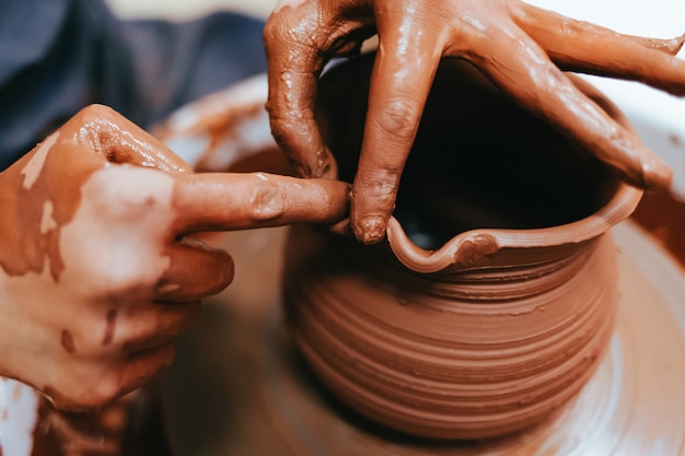 Woman potter shaping clay dishes on a pottery wheel