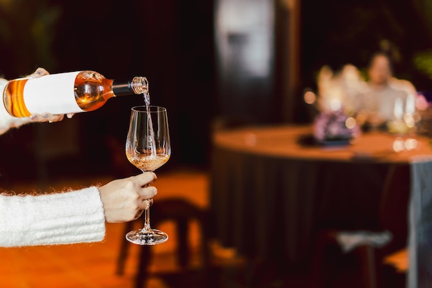 Woman pouring rose wine from bottle into glass lifestyle concept