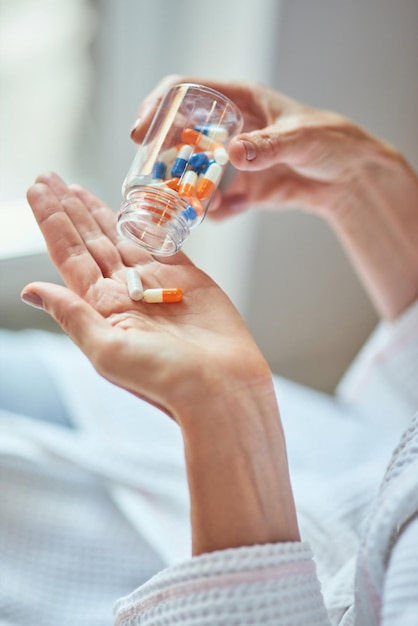 Woman pouring vitamin pills on palm