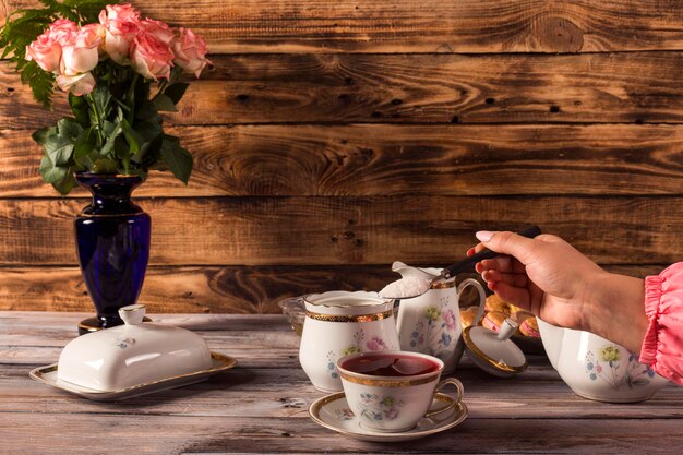 Photo woman pours tea from a teapot in a home