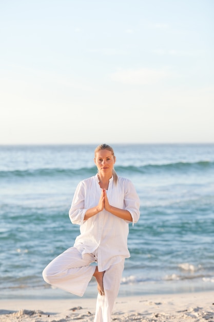 Woman practicing yoga at the beach