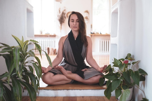 Woman practicing yoga lesson breathing meditating doing Padmasana exercise