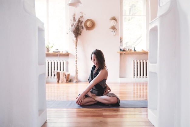 Woman practicing yoga lesson breathing meditating doing Twisted Padmasana