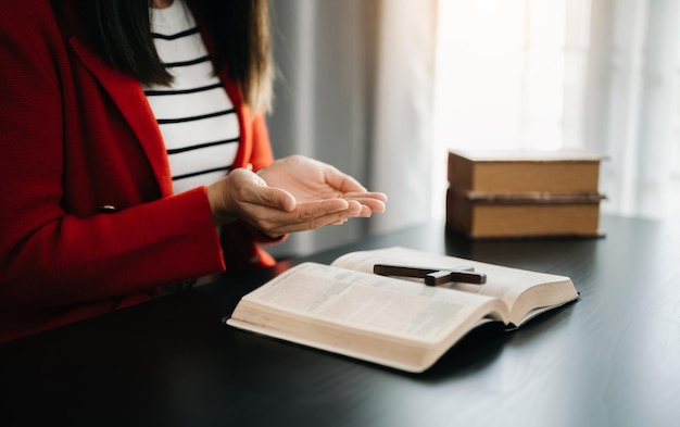 Woman praying on holy bible in the morningWoman hand with Bible praying Christian life crisis prayer to godxAxA