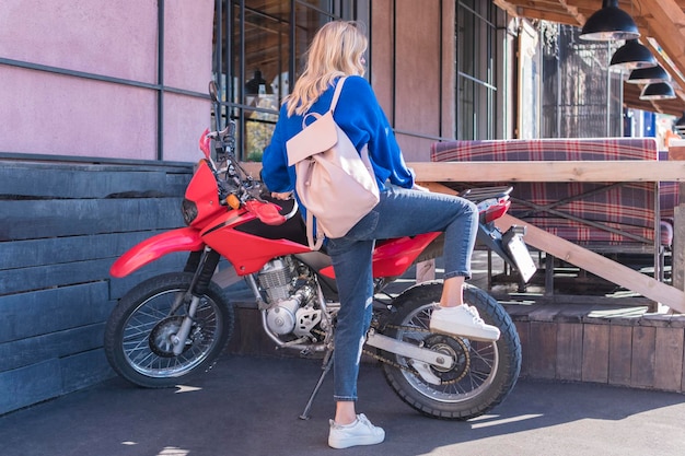 woman prepared to sit on a motorcycle parked at a cafe in the city