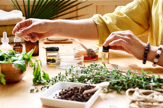 Photo woman prepares aromatherapy session with essential oil diffuser medical herbs oils and essences