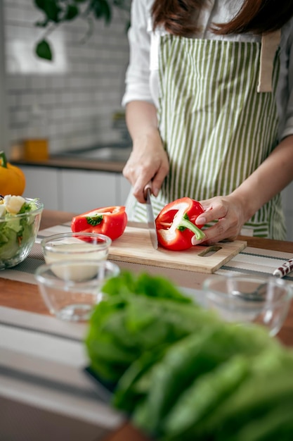 Woman prepares cooking healthy food from fresh vegetables and fruits in kitchen room