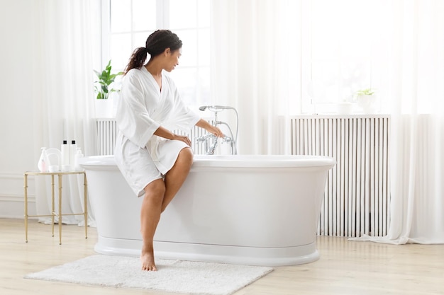 Woman preparing for a bath in bright room