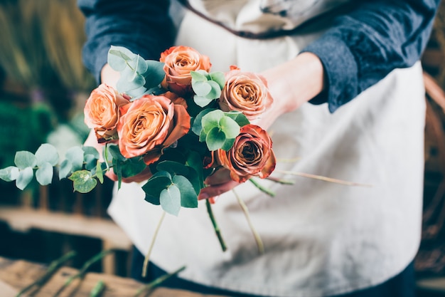 Photo woman preparing a bouquet of red roses