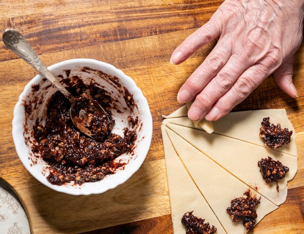 Woman preparing homemade rolls with jam at home