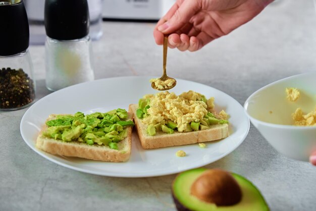 Woman preparing toasts with avocado Healthy food and dieting concept Organic product