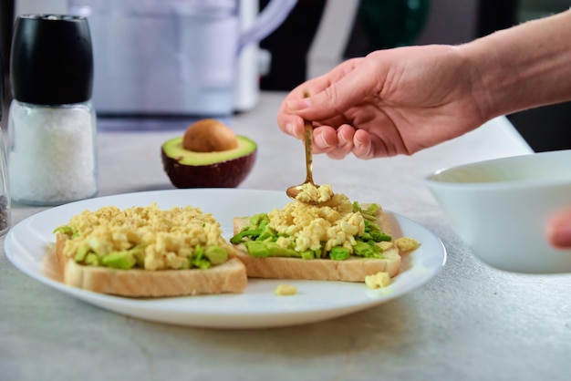 Woman preparing toasts with avocado healthy food and dieting concept organic product