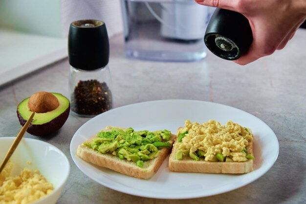 Woman preparing toasts with avocado Healthy food and dieting concept Organic product