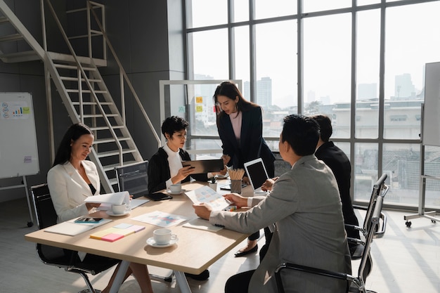 Woman present analysis to young lady team leader in business meeting with diversity people