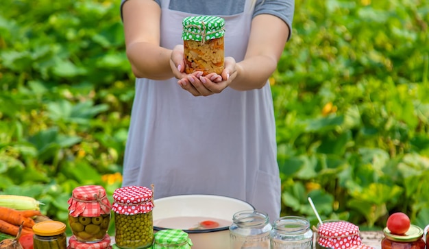 A woman preserves vegetables in jars Selective focus