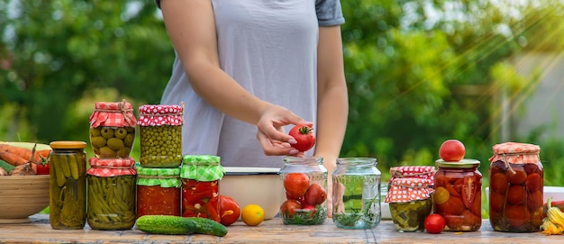 A woman preserves vegetables in jars Selective focus