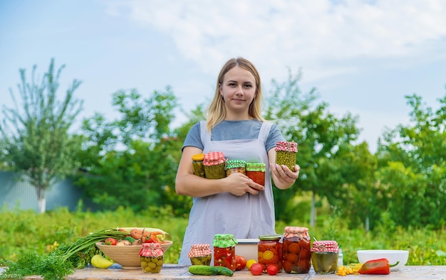 A woman preserves vegetables in jars Selective focus