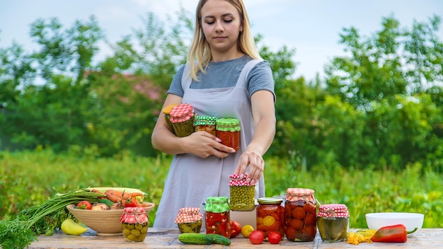 A woman preserves vegetables in jars Selective focus