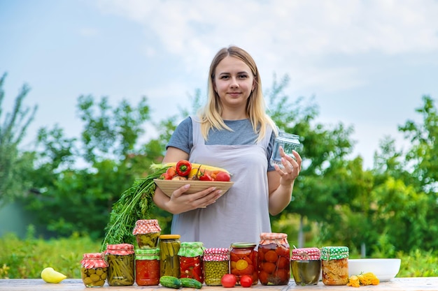 A woman preserves vegetables in jars Selective focus