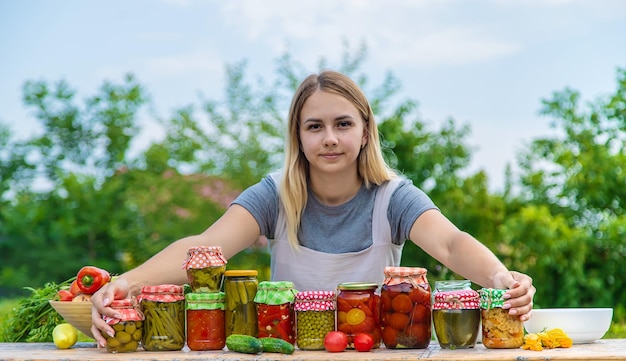 A woman preserves vegetables in jars Selective focus