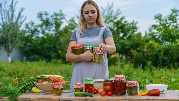 A woman preserves vegetables in jars Selective focus