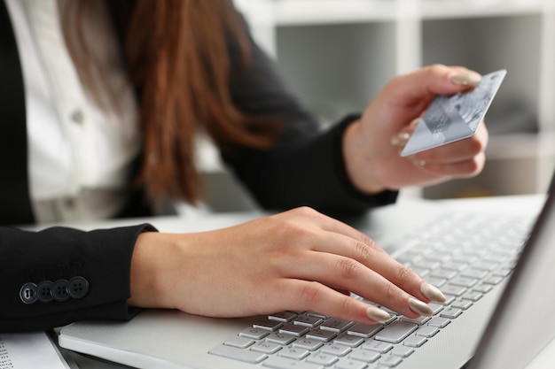 Woman press knobs on keyboard pay online with credit card remote shopping on laptop